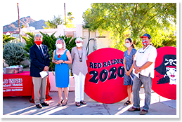 Adults posing in front of a Red Raiders 2020 sign