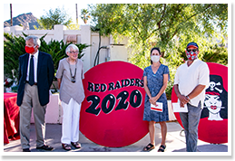Adults wearing masks posing in front of a Red Raiders 2020 sign